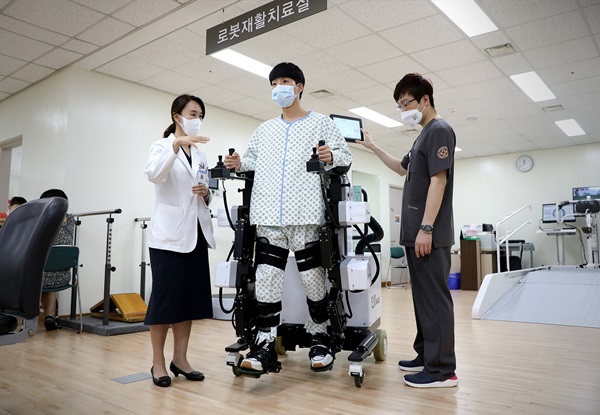 유지현 일산백병원 재활의학과 교수(왼쪽)가 재활 로봇을 활용한 로봇보조 보행 치료 방법을 설명하고 있다.
